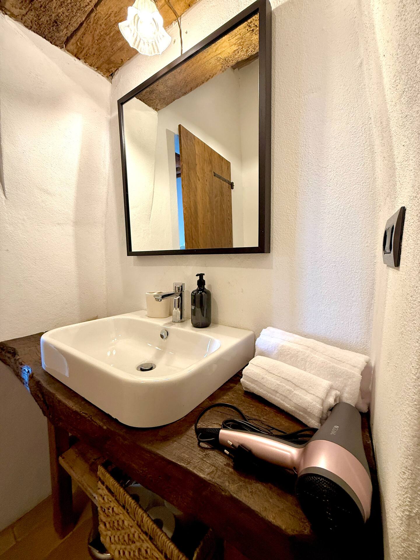 Dettaglio zona lavabo alla Torre della Soara: lavabo moderno bianco su piano in legno massiccio, asciugacapelli professionale e set di asciugamani bianchi in spugna pronti per gli ospiti. Dettaglio zona lavabo alla Torre della Soara: lavabo moderno bianco su piano in legno massiccio, asciugacapelli professionale e set di asciugamani bianchi in spugna pronti per gli ospiti.