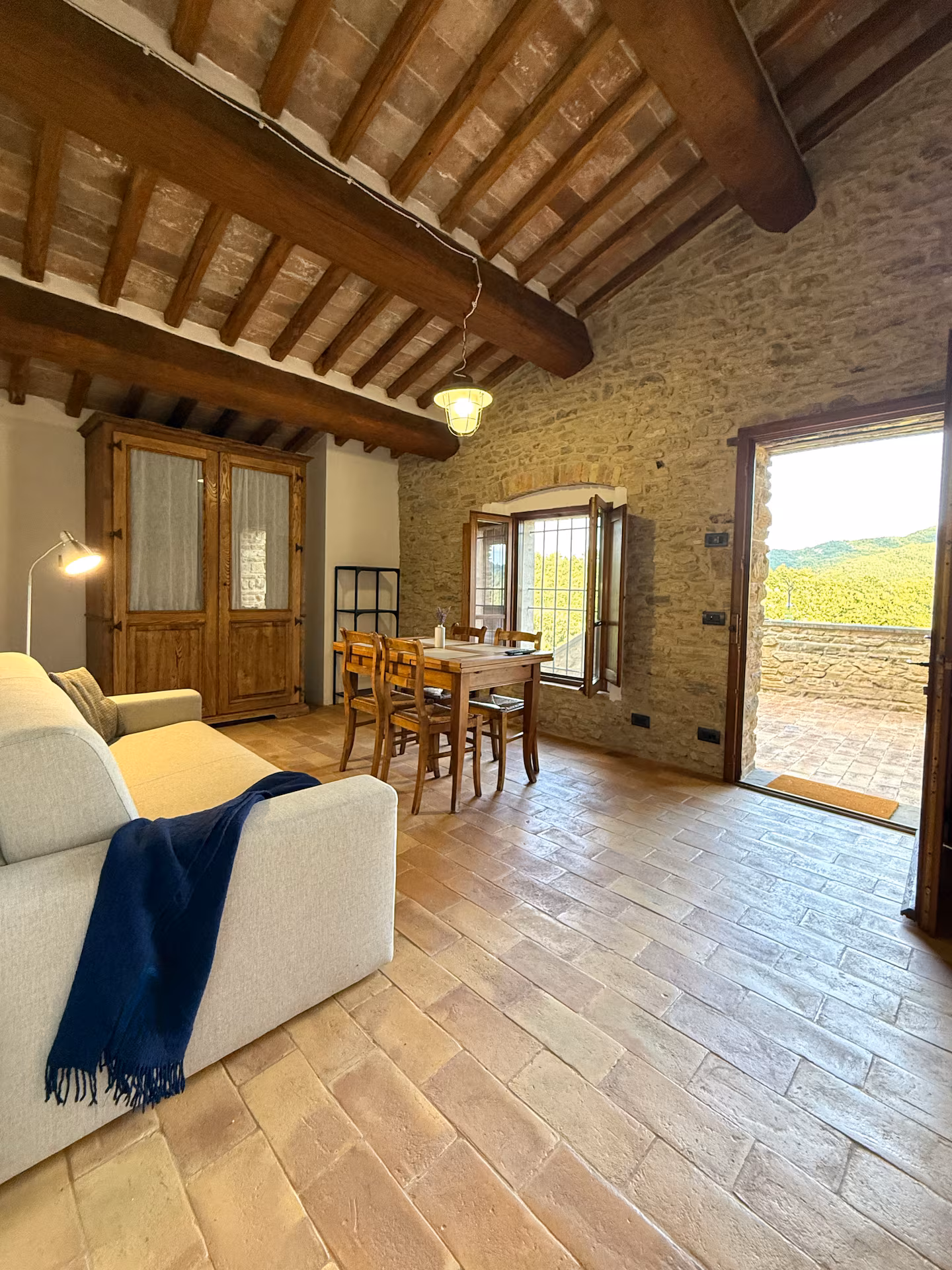 Soggiorno luminoso della Torre della Soara con divano moderno, tavolo da pranzo in legno, pareti in pietra originale e accesso diretto al terrazzo panoramico. Soggiorno luminoso della Torre della Soara con divano moderno, tavolo da pranzo in legno, pareti in pietra originale e accesso diretto al terrazzo panoramico.